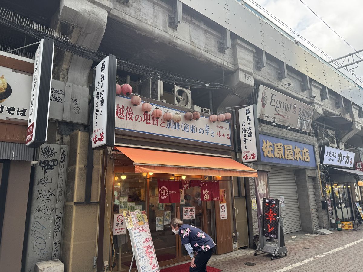 味の笛の入口。高架下の店構えで、赤い暖簾と提灯が並ぶ