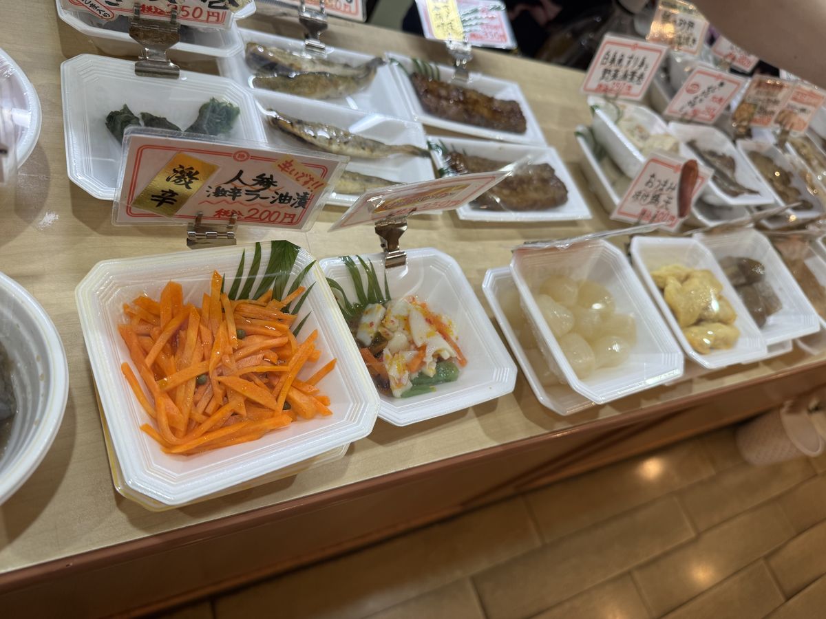 味の笛のつまみケース。人参ラー油漬や焼き魚など小皿のつまみがずらりと並ぶ