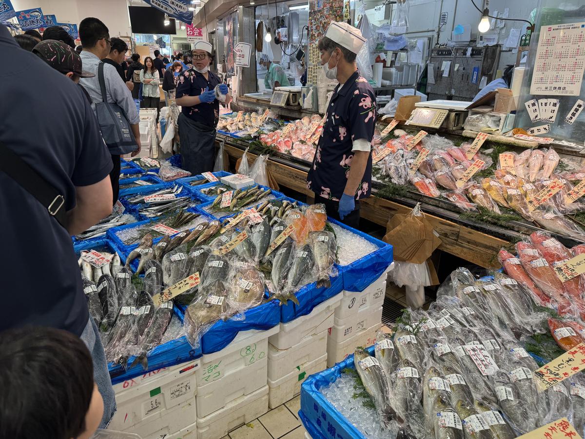 吉池1Fの鮮魚コーナー。氷の上に並んだ魚と店員