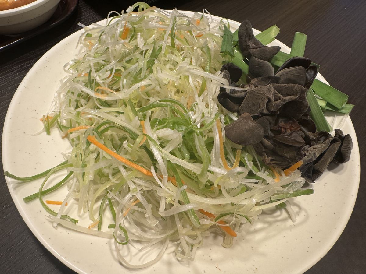 しゃぶ葉の野菜盛り。白髪ねぎやきくらげ、にんじんなどが皿に盛られている