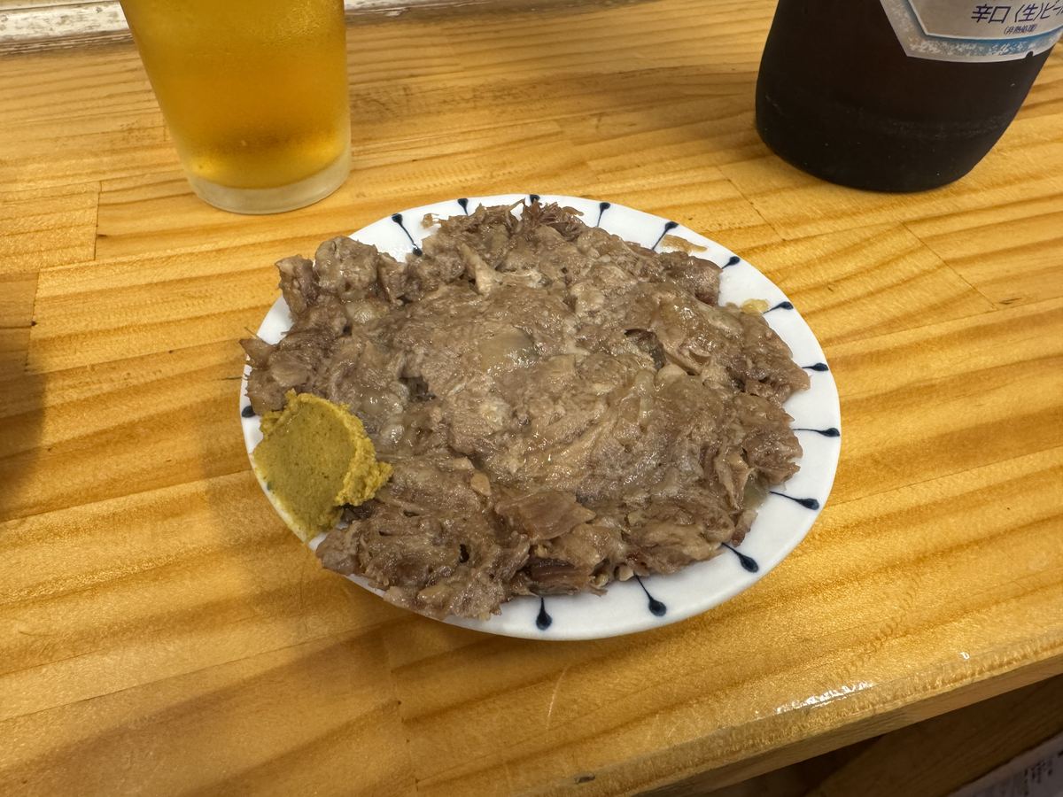 やきとんまるわの皿ナンコツ。からしを添えて、しぐれ煮のようにクタクタに煮込まれている