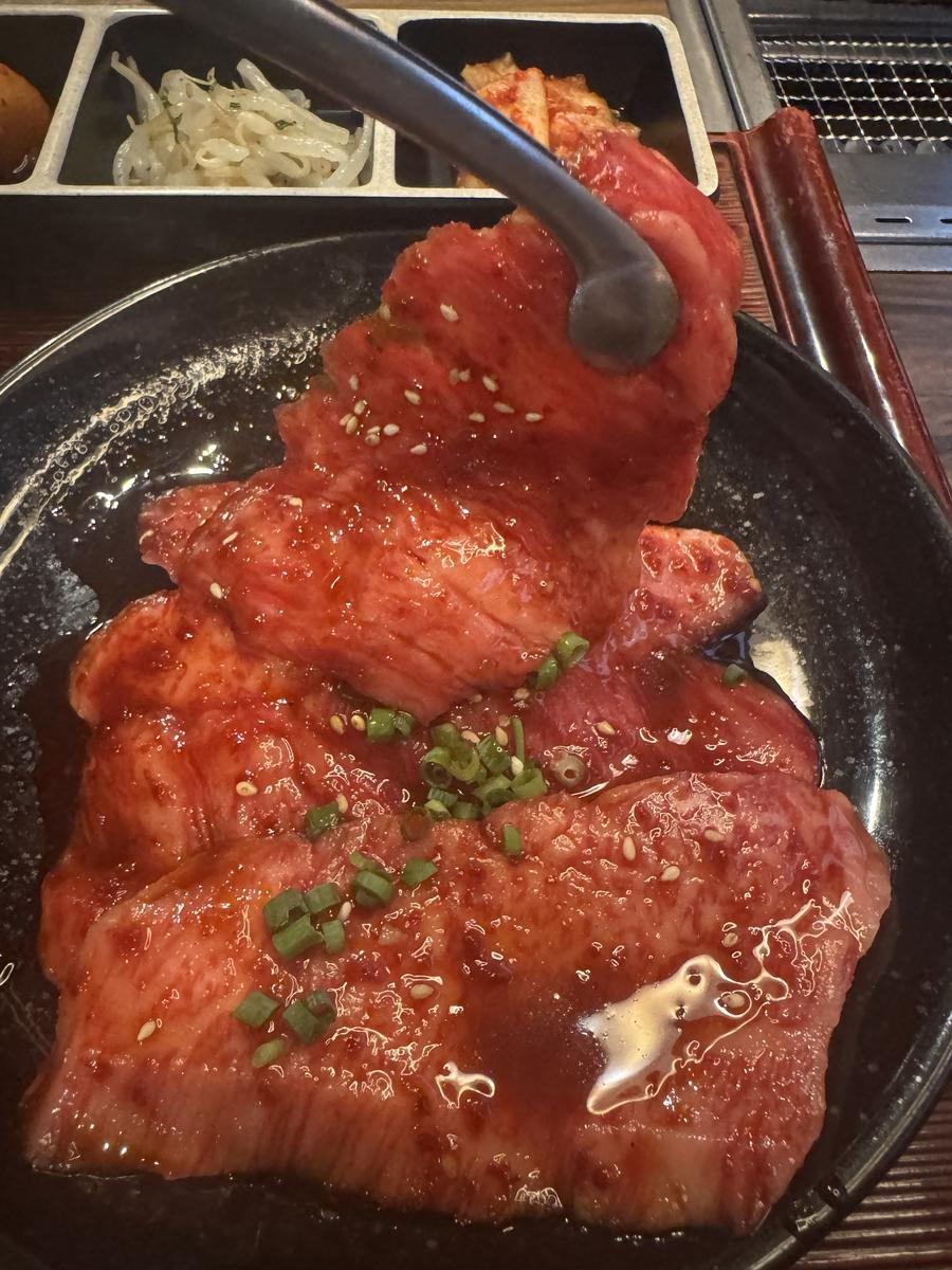 ゲタカルビのアップ。たれと薬味が絡んだ肉が網の上に並ぶ